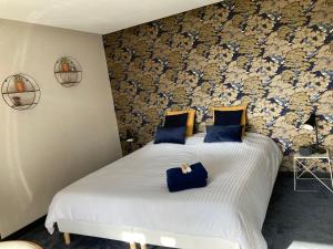 a bedroom with two beds with blue pillows at La Tuilerie Chambres d'Hôtes in Saint Die