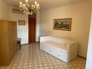 a bedroom with a bed and a chandelier at Condominio Canaima in Bibione