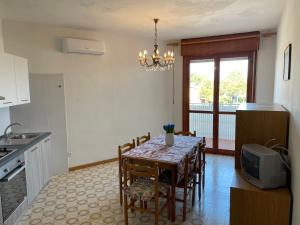 a kitchen and dining room with a table and a tv at Condominio Canaima in Bibione