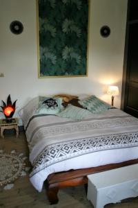 - une chambre dotée d'un lit avec une photo sur le mur dans l'établissement Les petites Mirabelles, à Noyers-sur-Cher