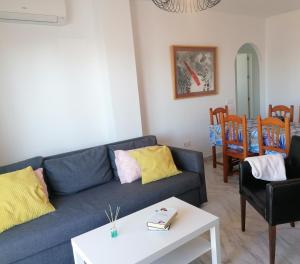 een woonkamer met een blauwe bank en een tafel bij BLUE Dreams in Mijas