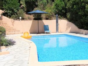 a swimming pool with a chair and an umbrella at Villa Mare E Sole by Interhome in Cavalaire-sur-Mer