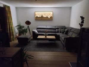 uma sala de estar com um sofá e uma mesa em Ferienwohnung Hahnenkammblick em Kitzbühel