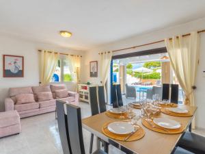 a dining room with a table and a couch at Holiday Home Anromi by Interhome in Cala Vadella
