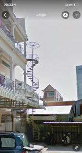 a blue car parked in front of a building with stairs at Sweet Home in Phnom Penh