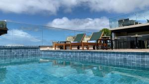 a swimming pool with two chairs and a table at Canto Hotel in Salvador
