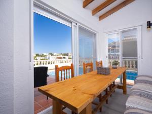 jadalnia z drewnianym stołem i widokiem na ocean w obiekcie Holiday Home La Lunella by Interhome w mieście Cumbre del Sol