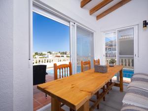 a dining room with a wooden table and views of the ocean at Holiday Home Lunella by Interhome in Cumbre del Sol