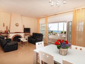 Una sala de estar con chimenea y una mesa y sillas. en Holiday Home Torre Mar by Interhome, en Miami Platja