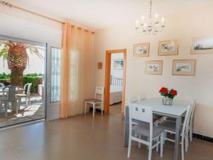 Un comedor con mesa y sillas y una ventana. en Holiday Home Torre Mar by Interhome, en Miami Platja