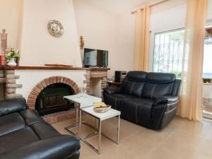 Una sala de estar con un sofá y una chimenea. en Holiday Home Torre Mar by Interhome, en Miami Platja