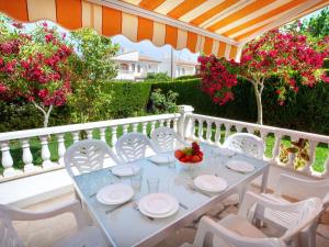 ミアミ・プラトーヤにあるHoliday Home Montalt VI by Interhomeの白いテーブルと椅子、花の咲くバルコニー