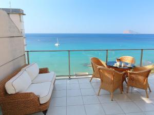 balcón con mesa, sillas y vistas al océano en Apartment Sotavento by Interhome, en Calpe