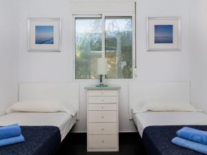 Apartment Brisa al Mar by Interhome في مورايرا: سريرين في غرفة بها نافذتين