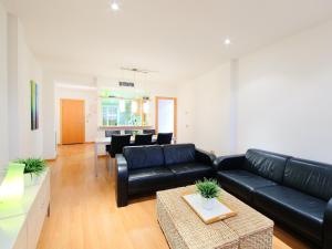 sala de estar con sofá de cuero negro y mesa en Apartment Sun Village I by Interhome en Palau-Saverdera