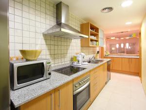 Apartment Sun Village I by Interhome في Palau-Saverdera: مطبخ مع فرن مايكرويف ومغسلة