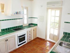 - une cuisine avec des placards blancs et du carrelage vert dans l'établissement Holiday Home Eretat by Interhome, à Adsubia