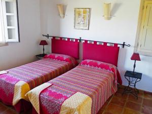 - 2 lits dans une chambre avec des couvertures rouges et roses dans l'établissement Holiday Home Eretat by Interhome, à Adsubia