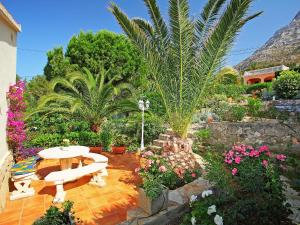 un jardín con un banco y algunas plantas y flores en Holiday Home Stella by Interhome, en Denia