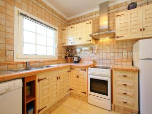 cocina con armarios de madera, fregadero y ventana en Holiday Home Stella by Interhome, en Denia