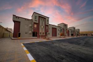 a row of buildings on a street with a cloudy sky at Mirada Gold Jizan - Chalets & Holiday Homes in Jazan