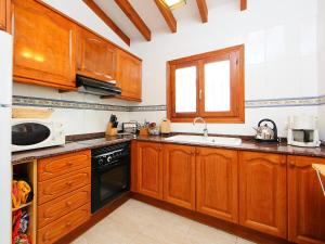 Monte PegoにあるHoliday Home Casa Esperanza by Interhomeのキッチン(木製キャビネット、シンク付)