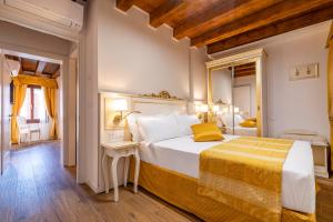 1 dormitorio con 1 cama grande con manta amarilla en Laguna D'oro Luxury Apartments, en Venecia
