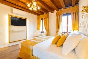 a bedroom with a large bed with a flat screen tv at Laguna D'oro Luxury Apartments in Venice