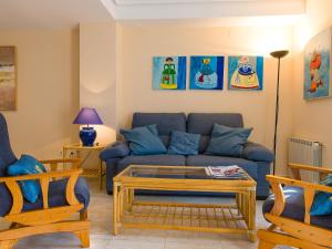 a living room with a blue couch and a table at Holiday Home Jardines Del Saladar by Interhome in Jávea