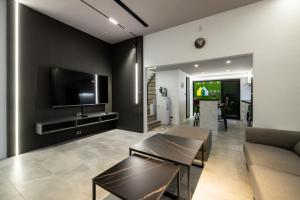 a living room with a couch and a tv on a wall at 澎湖好漫包棟民宿 in Magong