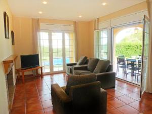 a living room with a couch and chairs and a television at Villa Villa Caleta by Interhome in Les tres Cales