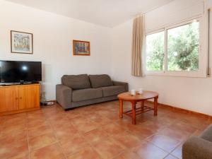ein Wohnzimmer mit einem Sofa und einem Tisch in der Unterkunft Villa Villa Cala Vidre B by Interhome in Les tres Cales