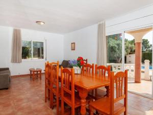 a dining room with a wooden table and chairs at Villa Villa Cala Vidre B by Interhome in Les tres Cales