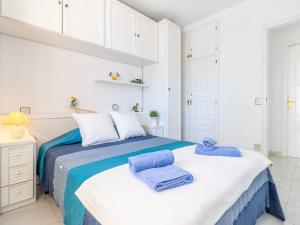 a white bedroom with a bed with towels on it at Apartment Club Nautic-9 by Interhome in Empuriabrava