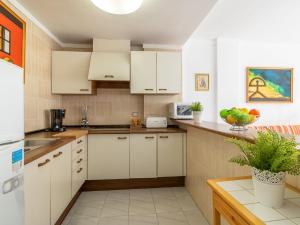 a kitchen with white cabinets and a table with a plant at Apartment Club Nautic-9 by Interhome in Empuriabrava