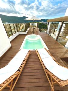 a deck with a swimming pool on top of a building at Cobertura Velejar em Condomínio Clube - com Área de Lazer in Governador Celso Ramos