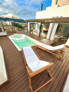 a deck with two lounge chairs and a swimming pool at Cobertura Velejar em Condomínio Clube - com Área de Lazer in Governador Celso Ramos +32 photos