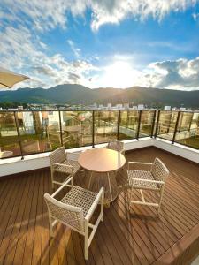 a patio with a table and chairs on a balcony at Cobertura Velejar em Condomínio Clube - com Área de Lazer in Governador Celso Ramos