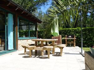 une table de pique-nique et un banc à côté d'un bâtiment dans l'établissement Holiday Home Villa Pallec by Interhome, à Ploemel