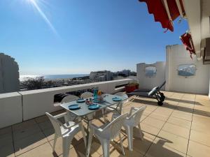 a table and chairs on a balcony with a view of the ocean at Apartment Jardins d'Ulysse II by Interhome in La Grande Motte