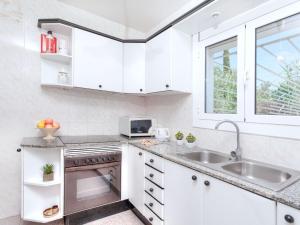 a kitchen with white cabinets and a sink at Holiday Home Cris by Interhome in Mont Barbat