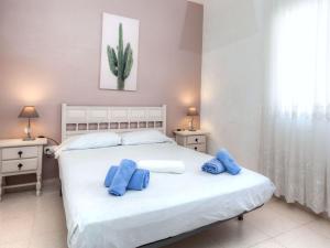 a bedroom with a white bed with blue pillows on it at Holiday Home Cris by Interhome in Mont Barbat