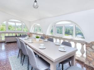 a dining room with a table and chairs and windows at Holiday Home Cris by Interhome in Mont Barbat