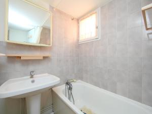 a bathroom with a sink and a bath tub and a mirror at Holiday Home Les Maisons du Golf by Interhome in Cap d'Agde
