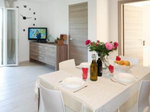 una sala da pranzo con un tavolo bianco e fiori di Apartment A Ca' Gialla - AEG100 by Interhome a Villanova dʼAlbenga