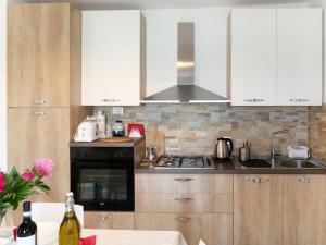 una cucina con armadi bianchi e piano cottura di Apartment A Ca' Gialla - AEG100 by Interhome a Villanova dʼAlbenga