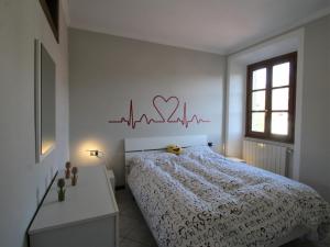 a bedroom with a bed with a heart sign on the wall at Apartment Vittore by Interhome in Verbania +13 photos