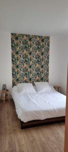 uma cama num quarto com uma cabeceira floral em Le P'tit Patio, Terrasse privative. em Lanester
