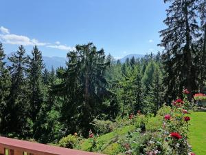 a view of a garden with flowers and trees at Studio Les Faverges-6 by Interhome in Crans-Montana