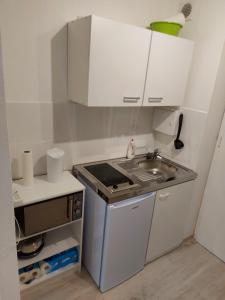 a small kitchen with a sink and white cabinets at Apartment Homburg Uni-Nähe in Homburg